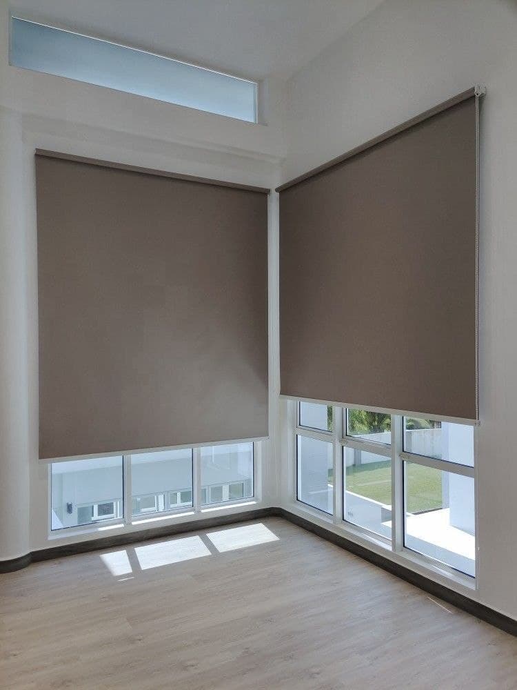 Full-height blackout roller blinds fitted across tall corner windows